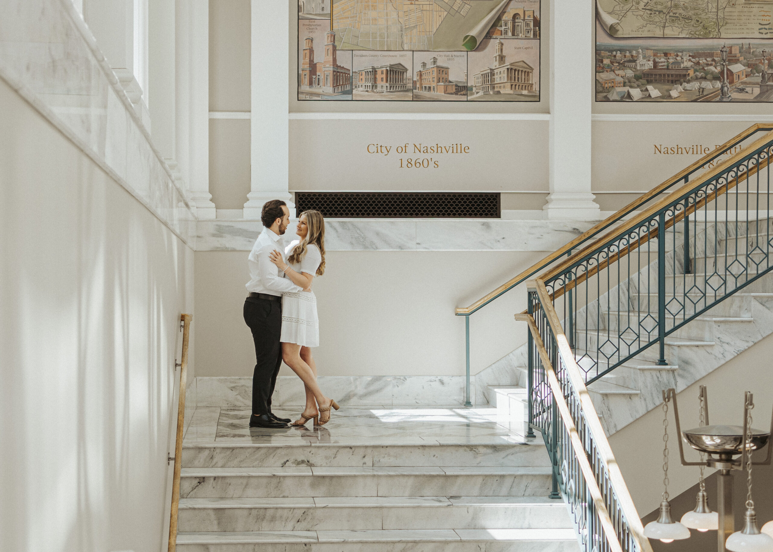 couple looking at each other on a stair landing in the Nashville Public Library